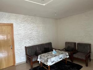 a dining room with two chairs and a table and a wall at Florida Waves in El Jadida