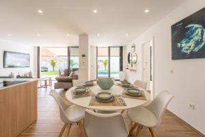 a dining room and living room with a table and chairs at Saras Village in Adeje
