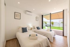 two beds in a room with white walls at Saras Village in Adeje +35 photos