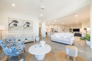a living room with a white couch and a table at 23B Airlie View in Airlie Beach