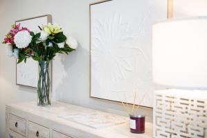 a vase of flowers sitting on top of a dresser at 23B Airlie View in Airlie Beach +18 photos