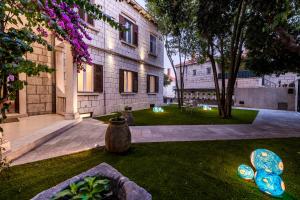 a courtyard of a building with a vase in the grass at Rebirth apartments in Dubrovnik