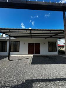 a large white building with two brown doors on it at Caribe Loft in Guápiles