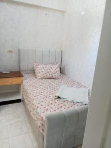 ein kleines Bett mit Kissen und Tisch in der Unterkunft chalet1 ch21 with a wonderful view 2 bed rooms terrace and garden green beach in El-Alamein + 44 Fotos