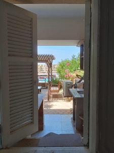 eine offene Tür zu einer Terrasse mit einem Tisch und einem Stuhl in der Unterkunft chalet1 ch21 with a wonderful view 2 bed rooms terrace and garden green beach in El-Alamein