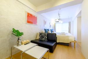 a bedroom with a bed and a couch and a table at 長者丸ビル 10 mins from Shibuya in Tokyo