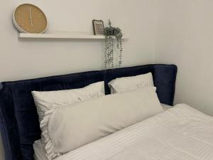 a bed with two pillows and a clock on a wall at מול הגלבוע Escape Suite in Gid‘ona