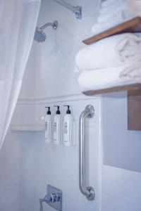 a bathroom with three soap bottles on a shelf at Marina Beach Motel in Santa Barbara +98 photos