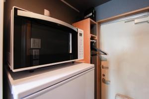 a microwave oven sitting on top of a refrigerator at Ivory Ekihigashi in Fukuoka