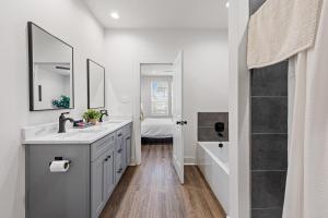 a white bathroom with two sinks and a shower at Voodoo House KING Bed Garage Fast WiFi 65 Tv in Lafayette