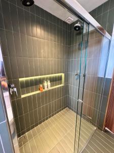 a bathroom with a shower with a glass door at Domo Jacarandá in Tocos do Mogi