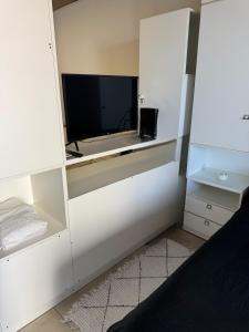 a room with a tv in a white wall at Alem Apartamento in La Porteña