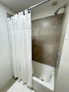a bathroom with a shower with a white shower curtain at Alem Apartamento in La Porteña +4 photos