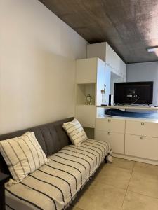 a living room with a couch and a kitchen at Alem Apartamento in La Porteña