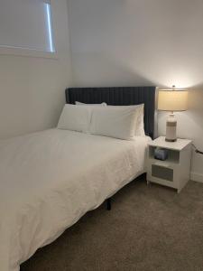 YYCにあるWestminister Manorのベッドルーム(白いベッド1台、ランプ付きのナイトスタンド付) +24枚の写真