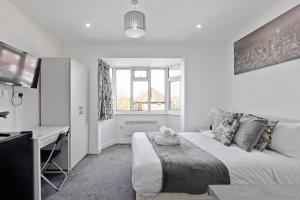 ein Schlafzimmer mit einem Bett und einem Schreibtisch darin in der Unterkunft Apartment - Sleeps 5 & Free Parking in Harrow