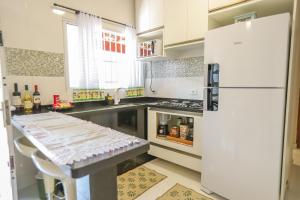 eine Küche mit einem weißen Kühlschrank und einer Theke in der Unterkunft Recanto da Varanda Seu cantinho de paz e descanso in Itatiba + 22 Fotos