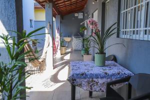 eine Terrasse mit einem Tisch und Topfpflanzen darauf in der Unterkunft Recanto da Varanda Seu cantinho de paz e descanso in Itatiba