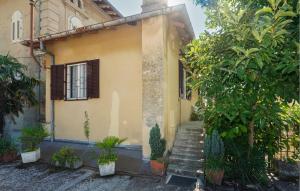 a yellow house with stairs and plants in front of it at Nice Apartment In Lovran With Wifi in Lovran