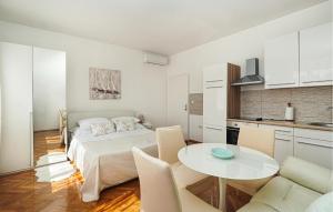 a bedroom with a bed and a table and a kitchen at Nice Apartment In Lovran With Wifi in Lovran +9 photos