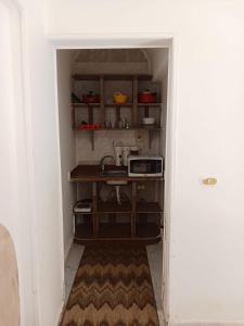 une petite cuisine avec un évier et un micro-ondes dans l'établissement R1 CH21 studio 2 beds poolside garden terrace Green Beach, à El Alamein