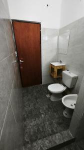 a bathroom with two toilets and a wooden door at Lavalle in Santiago del Estero +11 photos