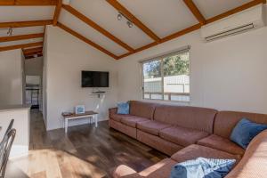 a living room with a couch and a table at Ocean Grove Holiday Park in Ocean Grove