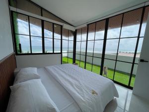 a bedroom with a large bed with large windows at GLAMSUITE FRENTE AL MAR con HIDRO in Montañita +27 photos