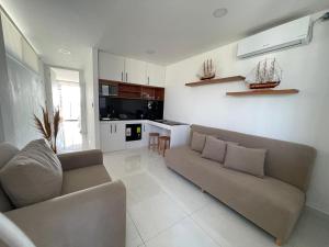 a living room with a couch and a kitchen at GLAMSUITE FRENTE AL MAR con HIDRO in Montañita