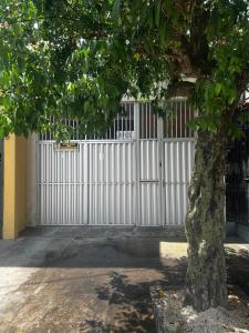a white gate with a tree in front of it at Studio no centro de Belém - COP 30 in Belém