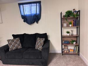 a black couch in a living room with a window at Sunny Days! Room for All and Pet Friendly in Pocatello