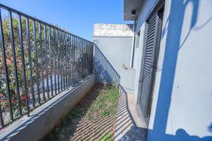 a balcony of a house with a blue fence at Loft aconchegante térreo prox Centro in Itatiba