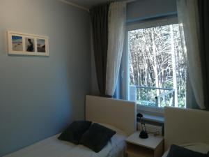 Schlafzimmer mit einem Bett und einem Fenster in der Unterkunft Apartament 20 in Dziwnówek