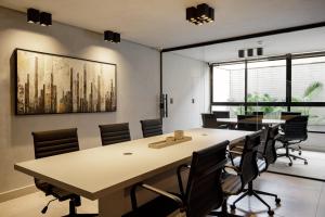 una sala de reuniones con una mesa grande y sillas en Alta Garden - Praia Exclusiva - Pé na areia, en João Pessoa