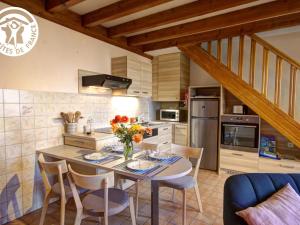 a kitchen with a table with flowers on it at Charmant Gîte avec Jardin Privatif, Proche Montbrison, Équipé Moderne et Confort Total - FR-1-496-117 in Pralong