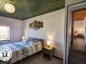 a bedroom with a bed and a wooden ceiling at Charmant Gîte avec Jardin Privatif, Proche Montbrison, Équipé Moderne et Confort Total - FR-1-496-117 in Pralong