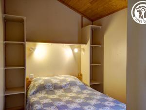 a small bedroom with a bed and shelves at Chalet 35m² avec terrasse et animaux acceptés à Les Noes - FR-1-496-244 in Saint-Rirand