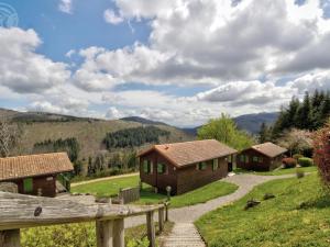 a log cabin in the mountains with a fence at Chalet 35m² avec terrasse et animaux acceptés à Les Noes - FR-1-496-244 in Saint-Rirand
