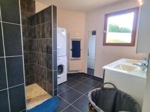 ein Badezimmer mit Waschmaschine und Waschbecken in der Unterkunft Confortable gîte de plain-pied avec jardin et garage sécurisé - FR-1-496-319 in Véranne + 18 Fotos