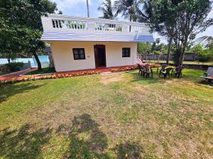 a house with a table and chairs in a yard at Garden Villa, Tranquil 2BR Retreat, Pool & Garden, Mahabalipuram in Mahabalipuram