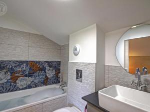 a bathroom with a tub and a sink and a mirror at Évasion Champêtre avec Spa, Activités ludiques et Confort moderne - FR-1-496-310 in Saint-Cyr-les-Vignes +27 photos