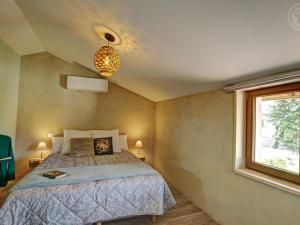 a bedroom with a bed and a window at Évasion Champêtre avec Spa, Activités ludiques et Confort moderne - FR-1-496-310 in Saint-Cyr-les-Vignes