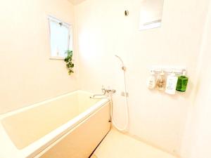 a white bathroom with a tub and a window at SouthernBeach Apartment in Chigasaki +73 photos