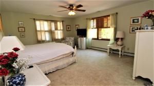 una camera da letto con un letto e un ventilatore a soffitto di The Duck Pond Cottage a Cape May