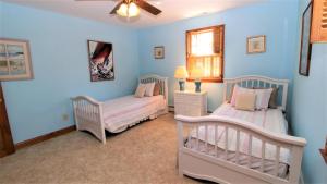 due letti in una stanza con pareti blu di The Duck Pond Cottage a Cape May