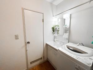 a white bathroom with a sink and a mirror at SouthernBeach Apartment in Chigasaki +70 photos