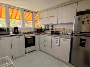 a kitchen with white cabinets and stainless steel appliances at Nativo Casa Colonial in Salento