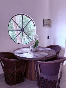 a wooden table with chairs and a round window at Casa Guaria Morada in Valle de Bravo +3 photos