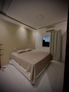 a bedroom with a large bed with a window at Flat Jijoca in Jijoca de Jericoacoara