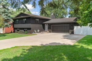 a house with a driveway and a garage at 2 Kings 2 Queens, comfy, big fenced yard in Mounds View